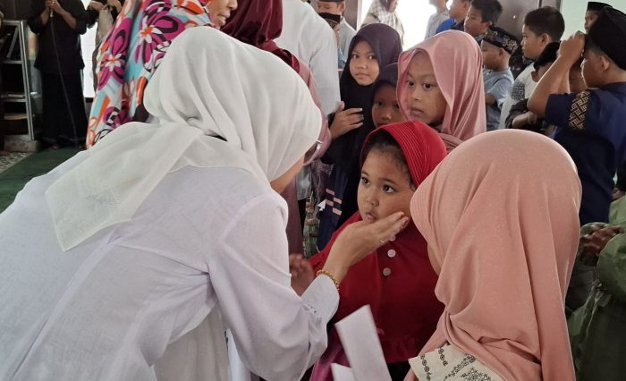 Para Wakil Rektor UNISKA turut memberikan santunan dan membelai hangat salah satu peserta, mencerminkan kasih sayang dan kepedulian yang tulus.